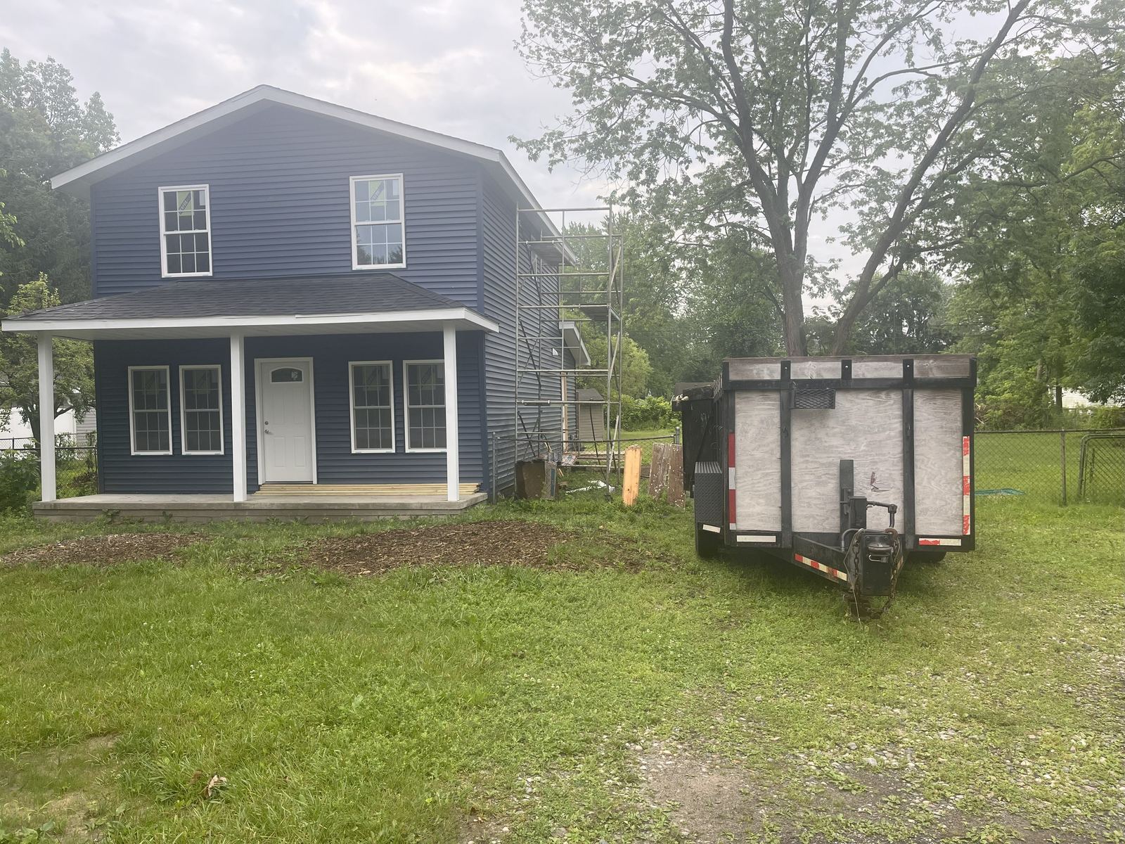 Kincaide dumpster trailer staged on the lawn beside a home renovation